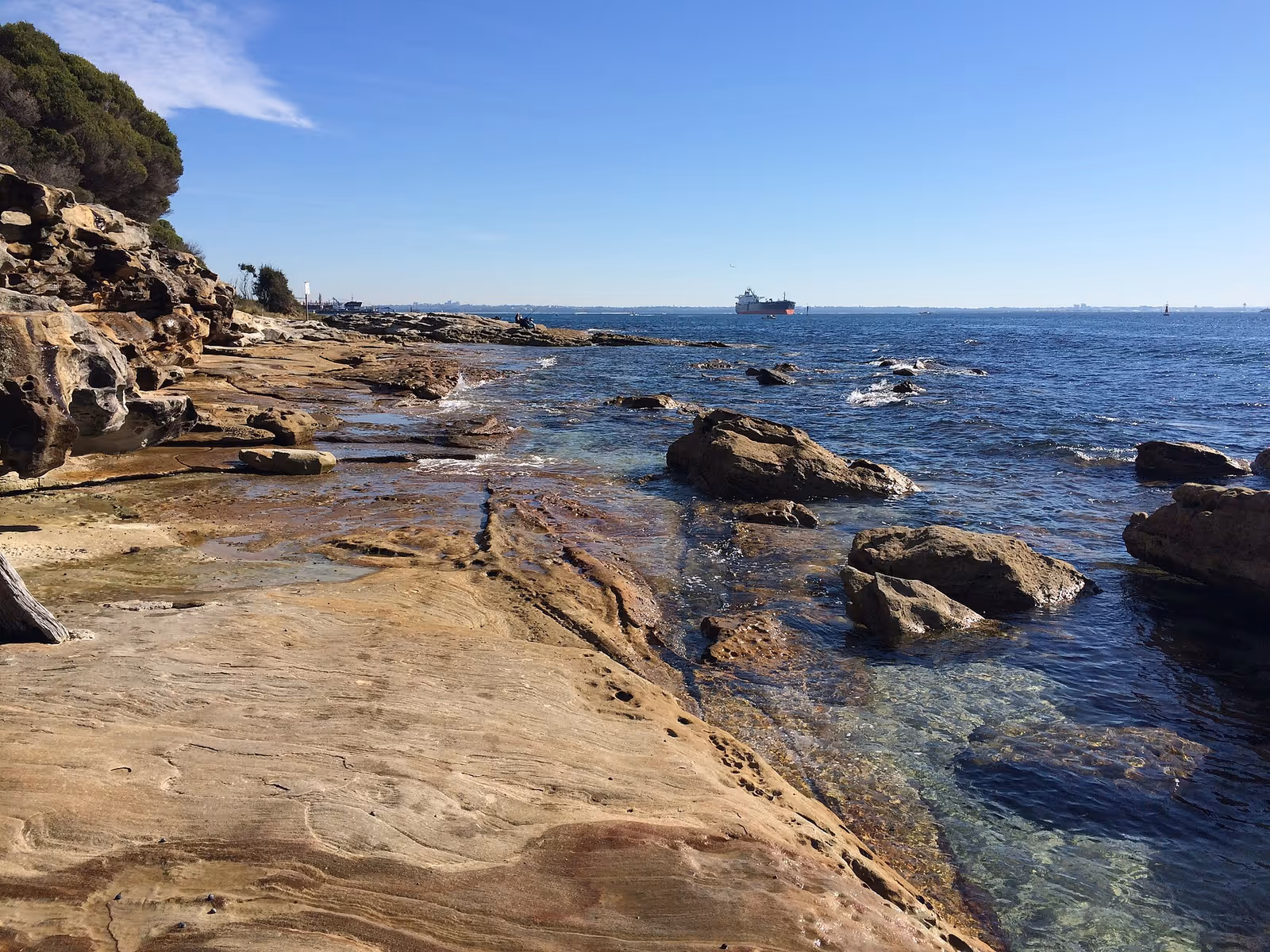 The chalk sea stacks of Botany Bay seen from the clifftop, with sand and rock pools exposed at low tide