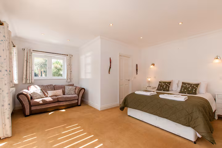 Ground-floor king bedroom with garden view and velvet sofa